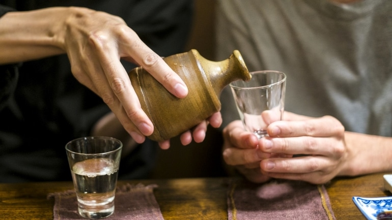 a man pouring sake into the other's glass